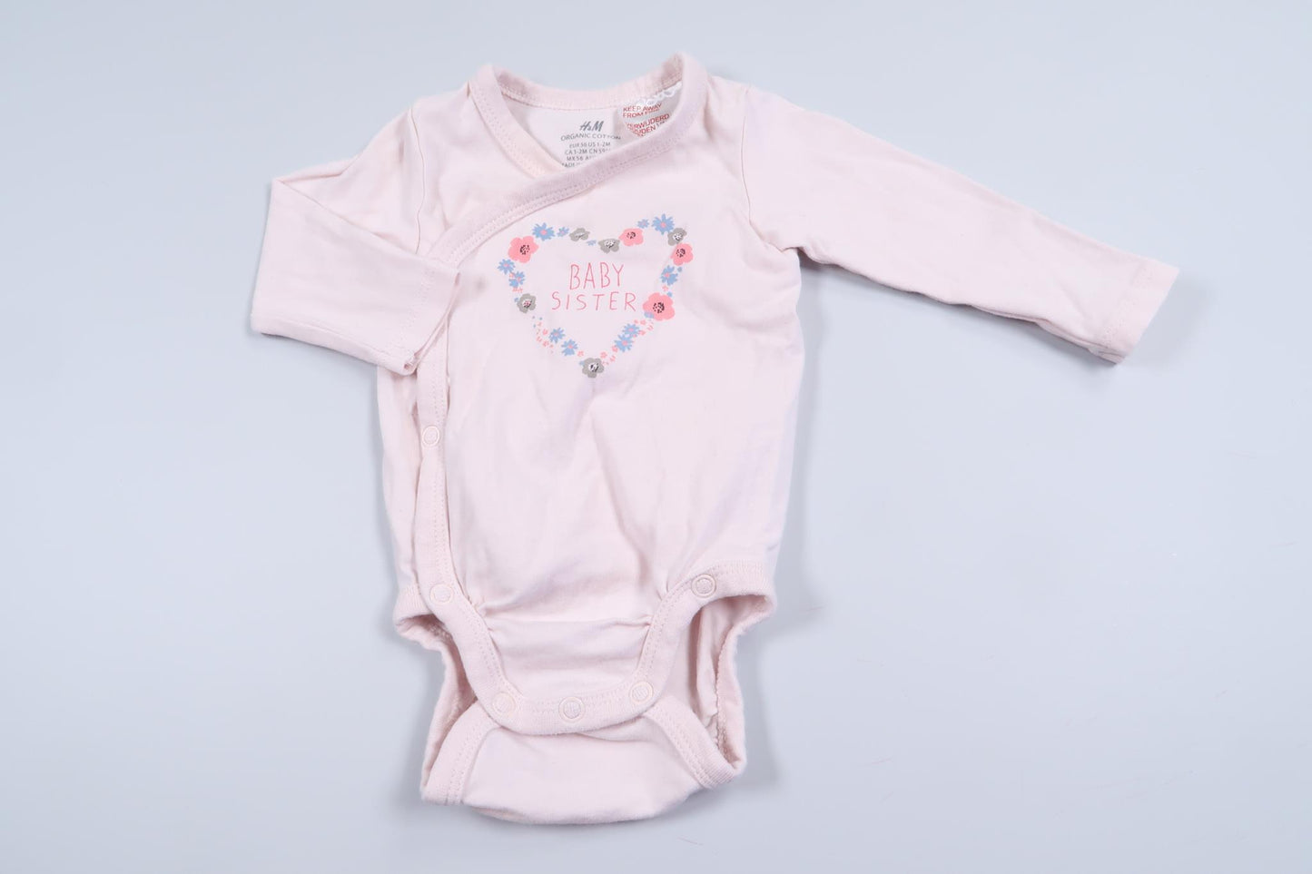 Rosa långärmad omlottbody "Baby Sister" från H&M i storlek 56