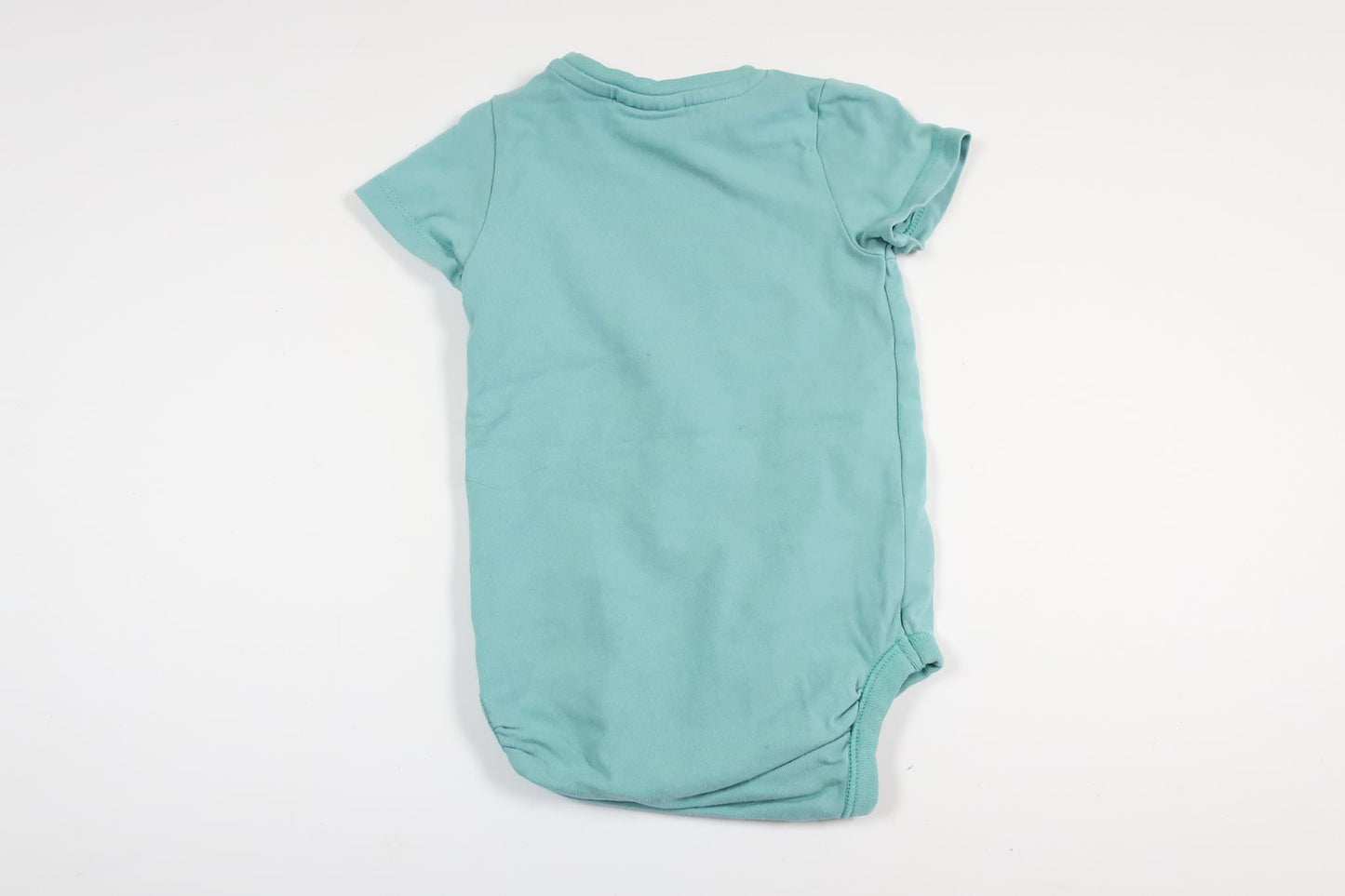 Ljusblå kortärmad body med text från Kappahl i storlek 62