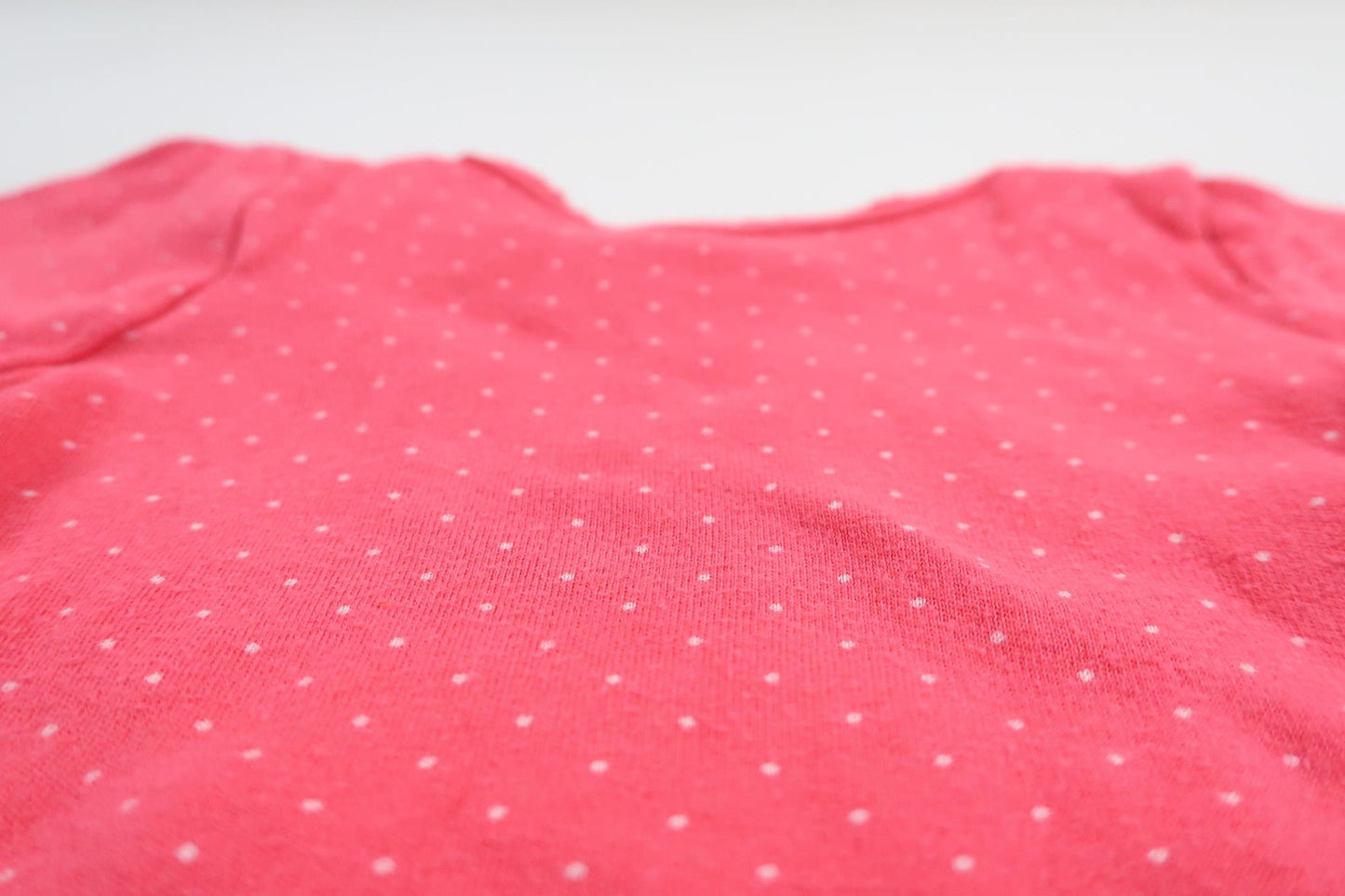 Neon rosa prickig långärmad body från HEMA i storlek 50/56