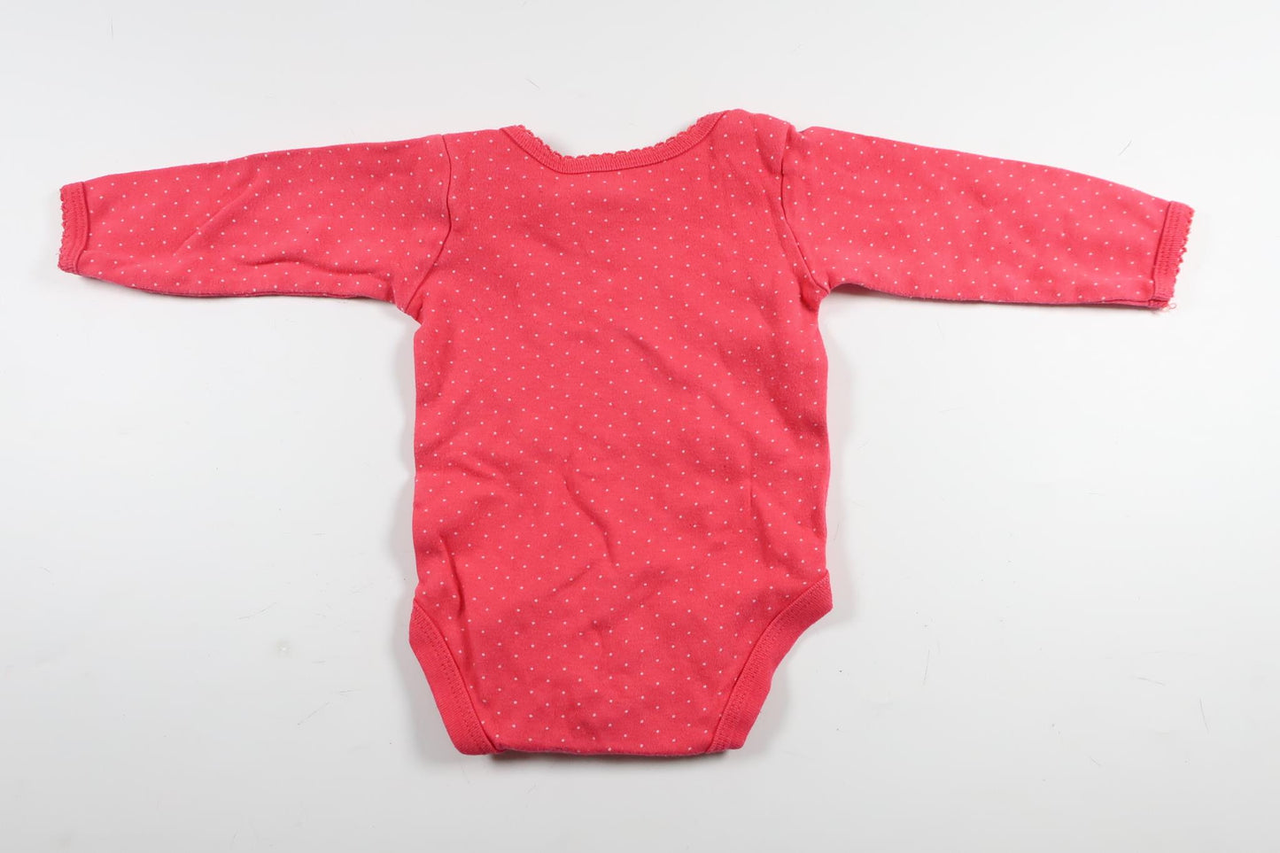 Neon rosa prickig långärmad body från HEMA i storlek 50/56