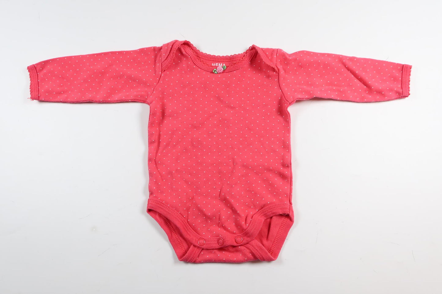 Neon rosa prickig långärmad body från HEMA i storlek 50/56